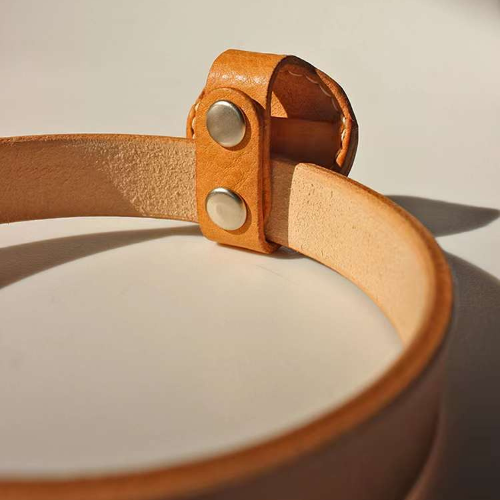View the backside details of the natural color Leather Airtag Chain, including the button attachment.
